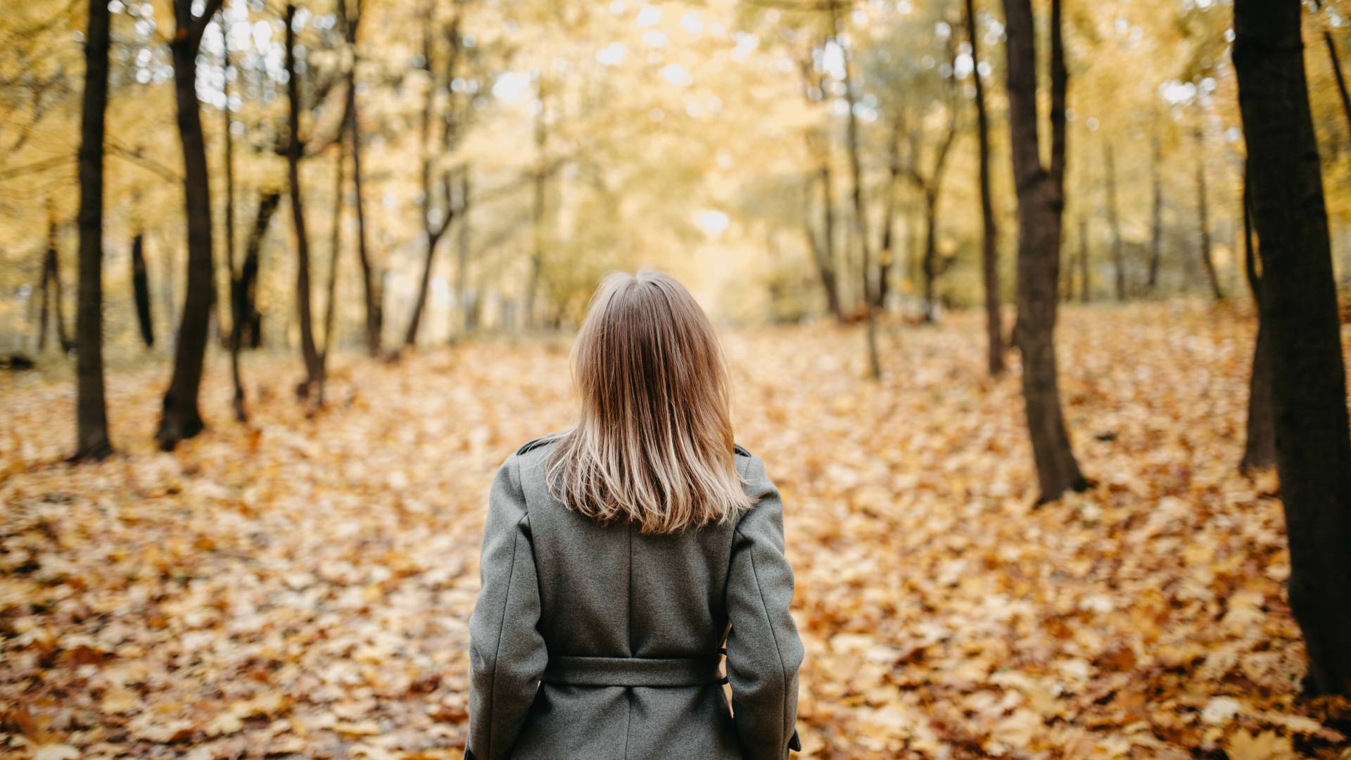 Woman walking through the forest in autumn