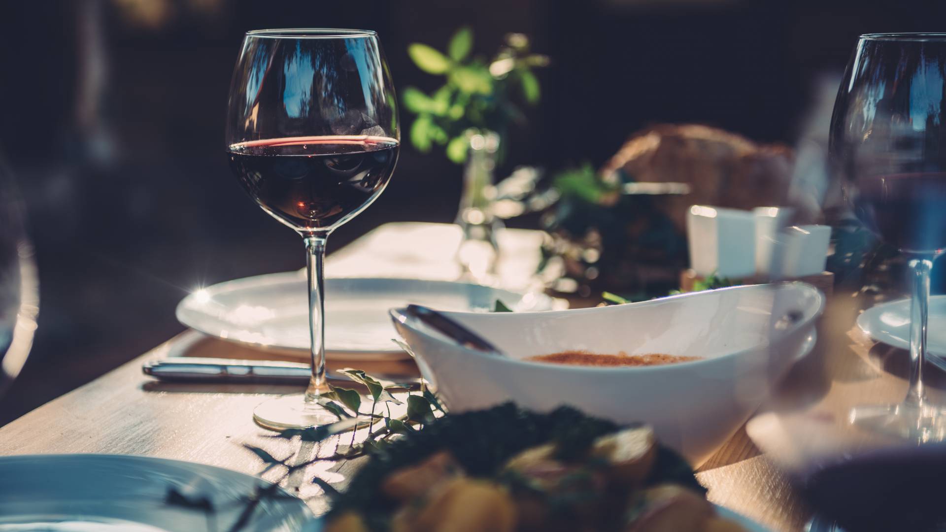 Ein Glas Wein auf einem gedeckten Tisch. Abendessen in einem Hotel