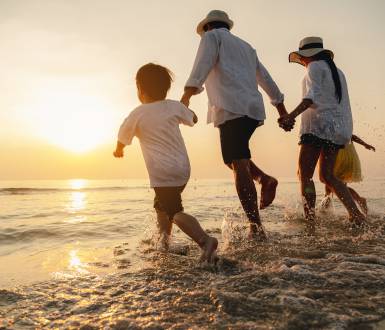 Happy asian family at consisting father, mother,son and daughter having fun playing beach in summer vacation on the beach
