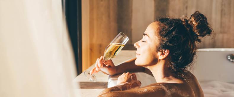 Frau trinkt Sekt in Badewanne