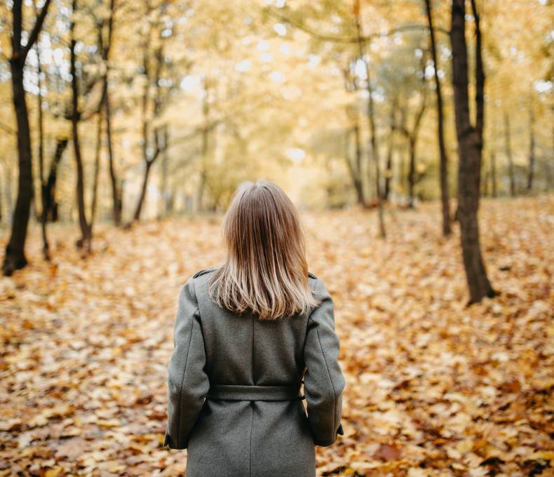 Woman walking through the forest in autumn